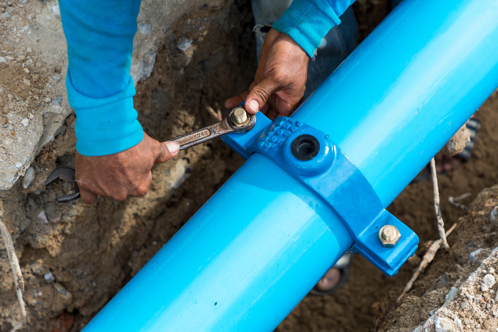 Man Using A Large Wrench On Water Pipes